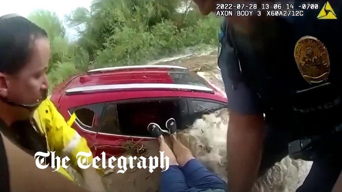 Die Polizei in Arizona hat ein Video von Mitarbeitern veröffentlicht, die eine Frau retten, die am Donnerstag in Apache Junction, Arizona, USA, von steigenden Fluten in ihrem Auto eingeschlossen wurde. Das von der Apache Junction Police Department veröffentlichte Video mit der Körperkamera zeigt Beamte, die der eingeschlossenen Autofahrerin sagen, sie solle sich „beeilen“ und „das Seil greifen“, damit sie sie aus dem Auto ziehen können, während das Wasser steigt. Dass auch ihr Hund mit im Fahrzeug eingeklemmt sei, schreit die Frau zurück: „Haben Sie mich erwischt? Hol meinen Hund!“ Die Retter ziehen sie heraus und rufen: „Komm, beeil dich, das &hellip;