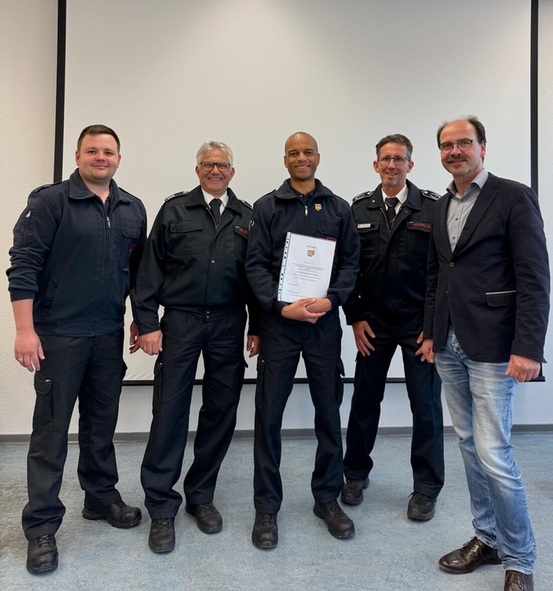 Stadtjugendfeuerwehrwart Tom Noquer wird mit der Ehrennadel des Kreisfeuerwehrverbands ausgezeichnet. Bürgermeister Langhard gratuliert.