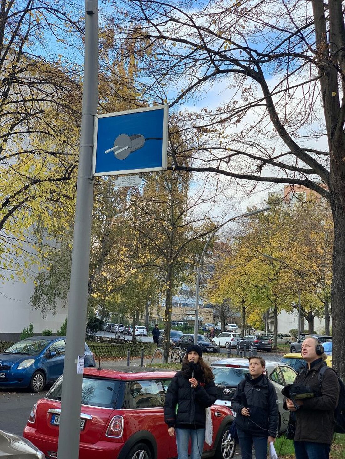 Unter dem Titel „Stadt verhören“ steht ab sofort ein neuer digitaler Hörspaziergang für den Bezirk Tempelhof-Schöneberg zur Verfügung. Abseits üblicher Wege wird über die Geschichte des Nationalsozialismus informiert. Reinhören lohnt sich! Gemeinsam mit Mitgliedern des Jugendparlaments Tempelhof-Schöneberg waren Fabian Eckert und Melanie Eis vom Verein Bidigi e.V. vergangenen Herbst rund um den Bayerischen Platz in Schöneberg unterwegs. Besucht wurde ein von den Künstler:innen Renata Stih und Frieder Schnock 1993 gestalteter Orte des Erinnerns, ein Flächendenkmal bestehend aus an Straßenschildern angebrachten Informationstafeln zur Verfolgung der Berliner Jüd:innen während der NS-Diktatur. Begleitet wurden sie dabei von Magdalene Roesch vom Verein Quartier Bayerischer …