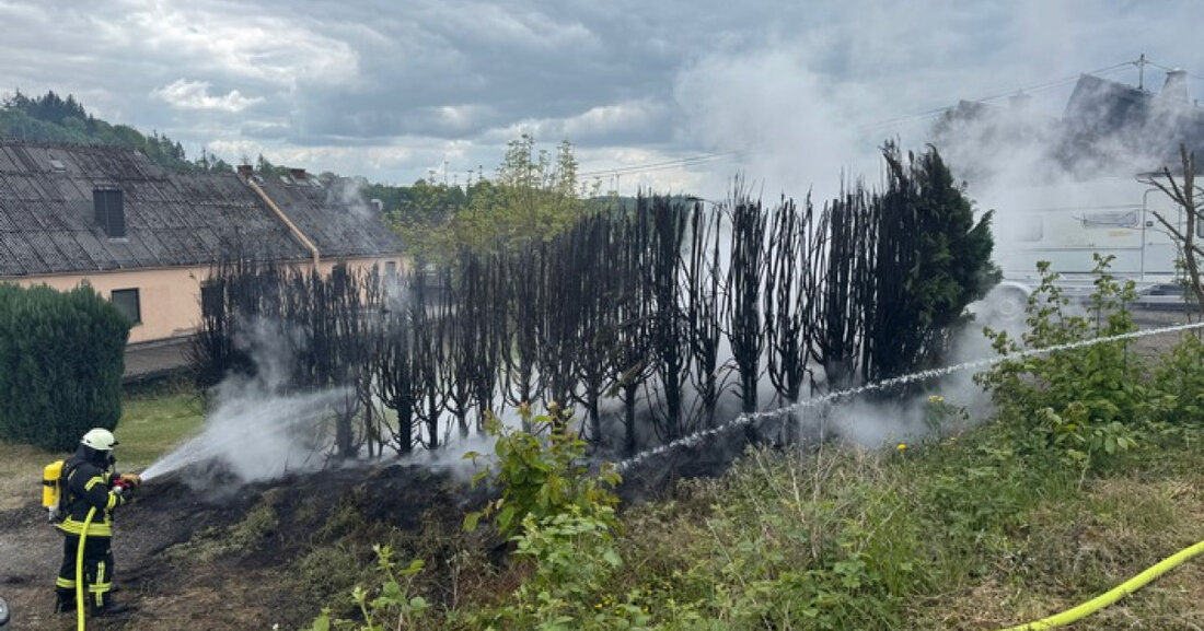 Feuerwehr VG Westerburg löscht am 17.05.2025 einen Brand einer Tujahecke in Hintermühlen, Rauchwolke weithin sichtbar.